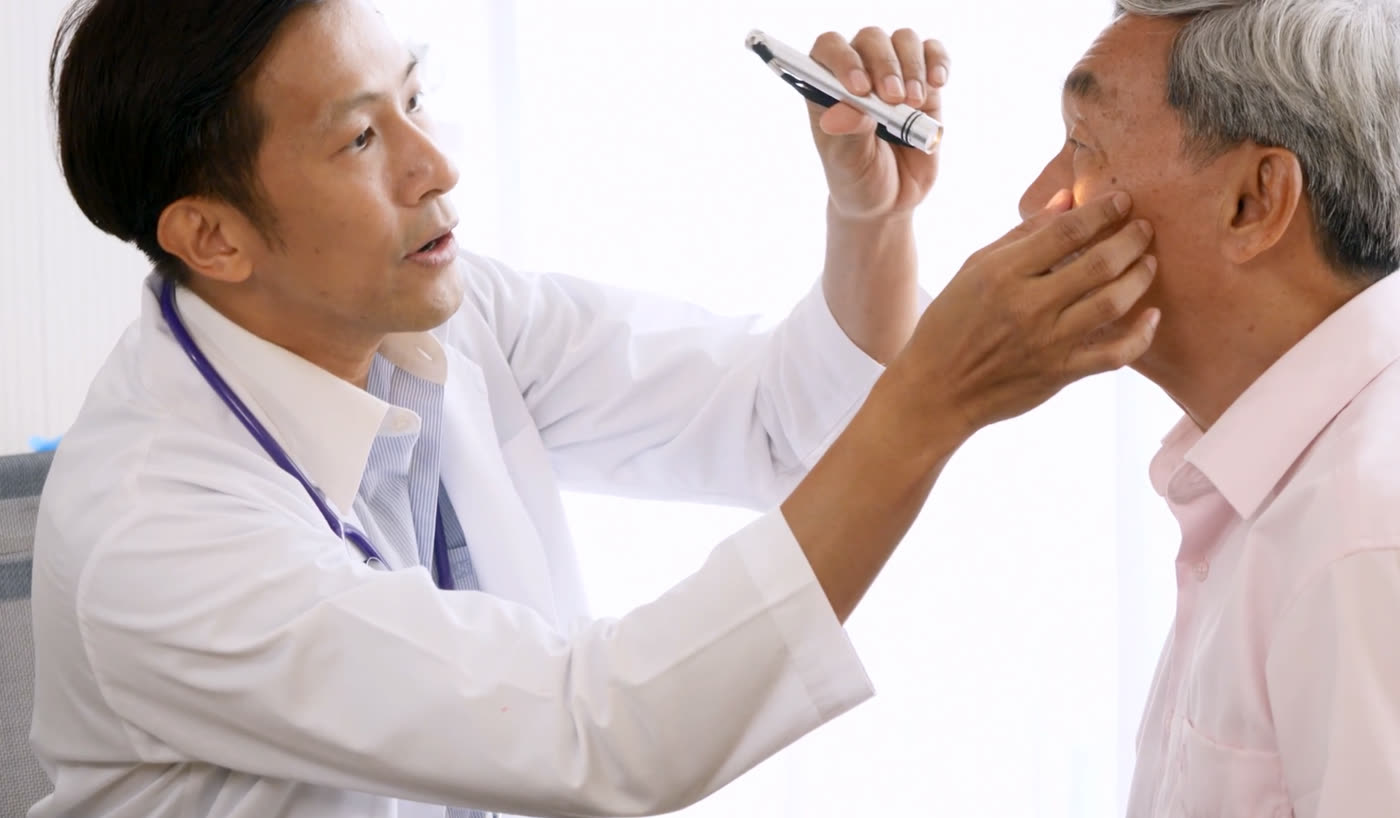 Ophthalmologist examining an older patient’s eye